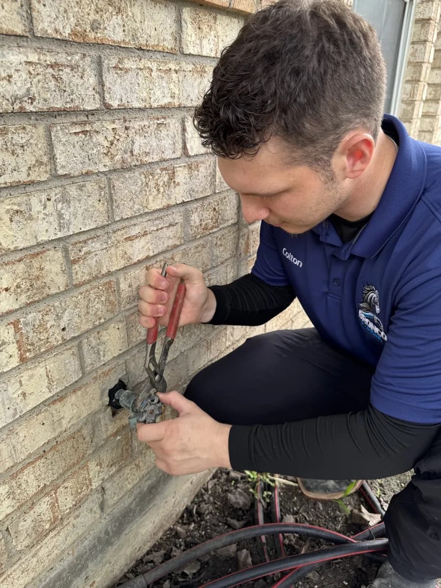 Colton Staley performing slab leak repair at a DFW residence for Bronco Plumbing